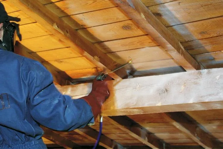 Pulverisation de traitement sur charpente en bois